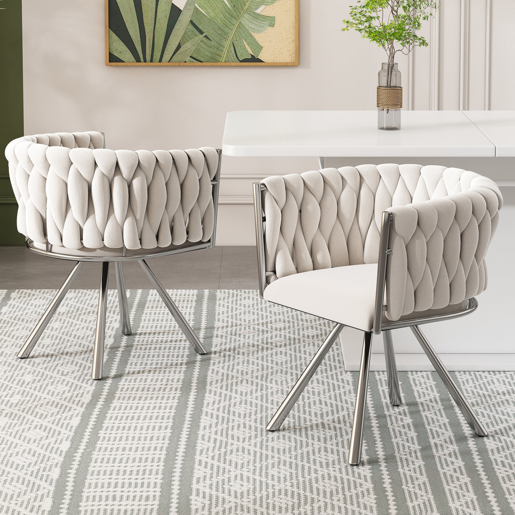 Two modern chairs with quilted design in a room with a painting and plant on the wall.