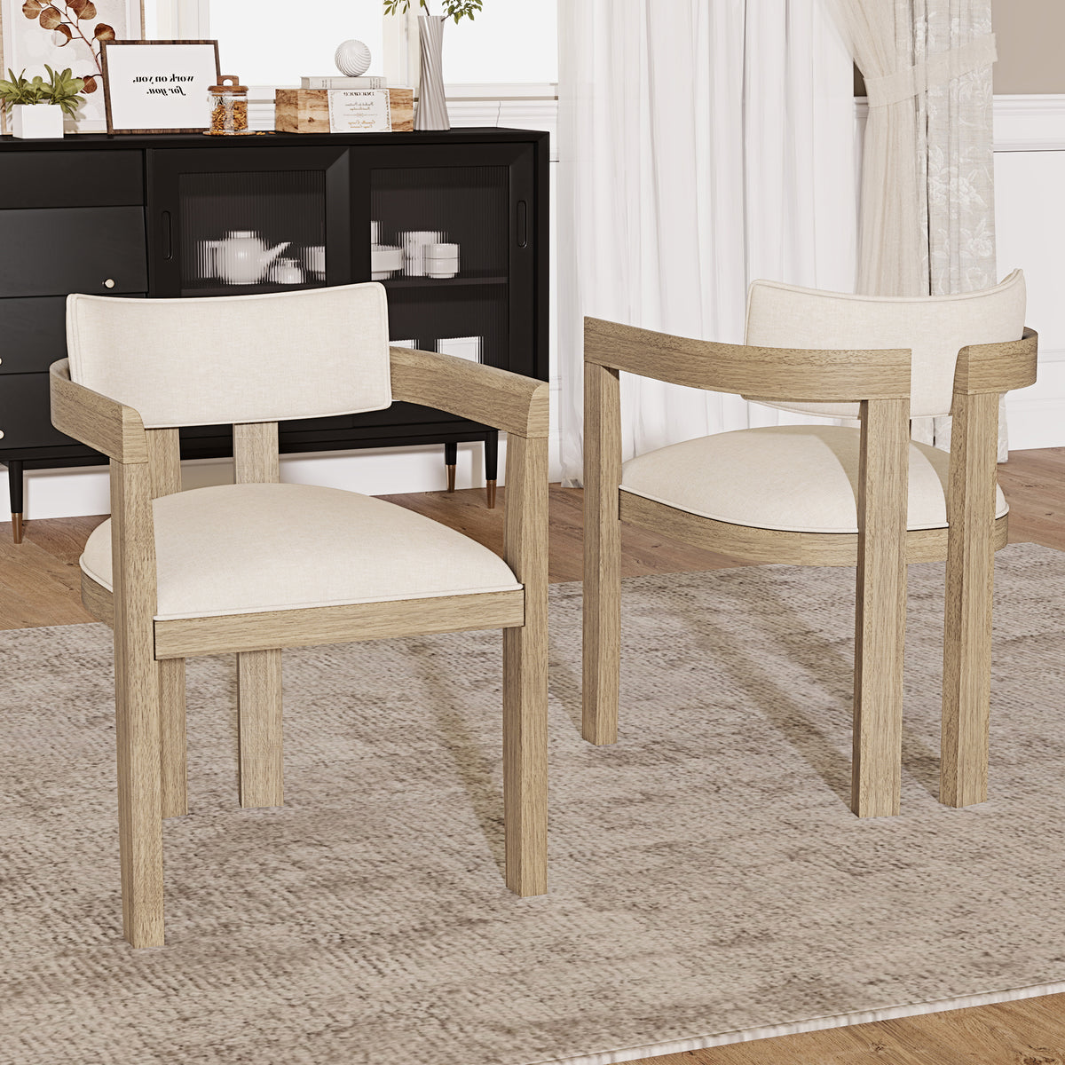 Two wooden chairs with white cushions on a patterned rug in a room with a black cabinet and white curtains.