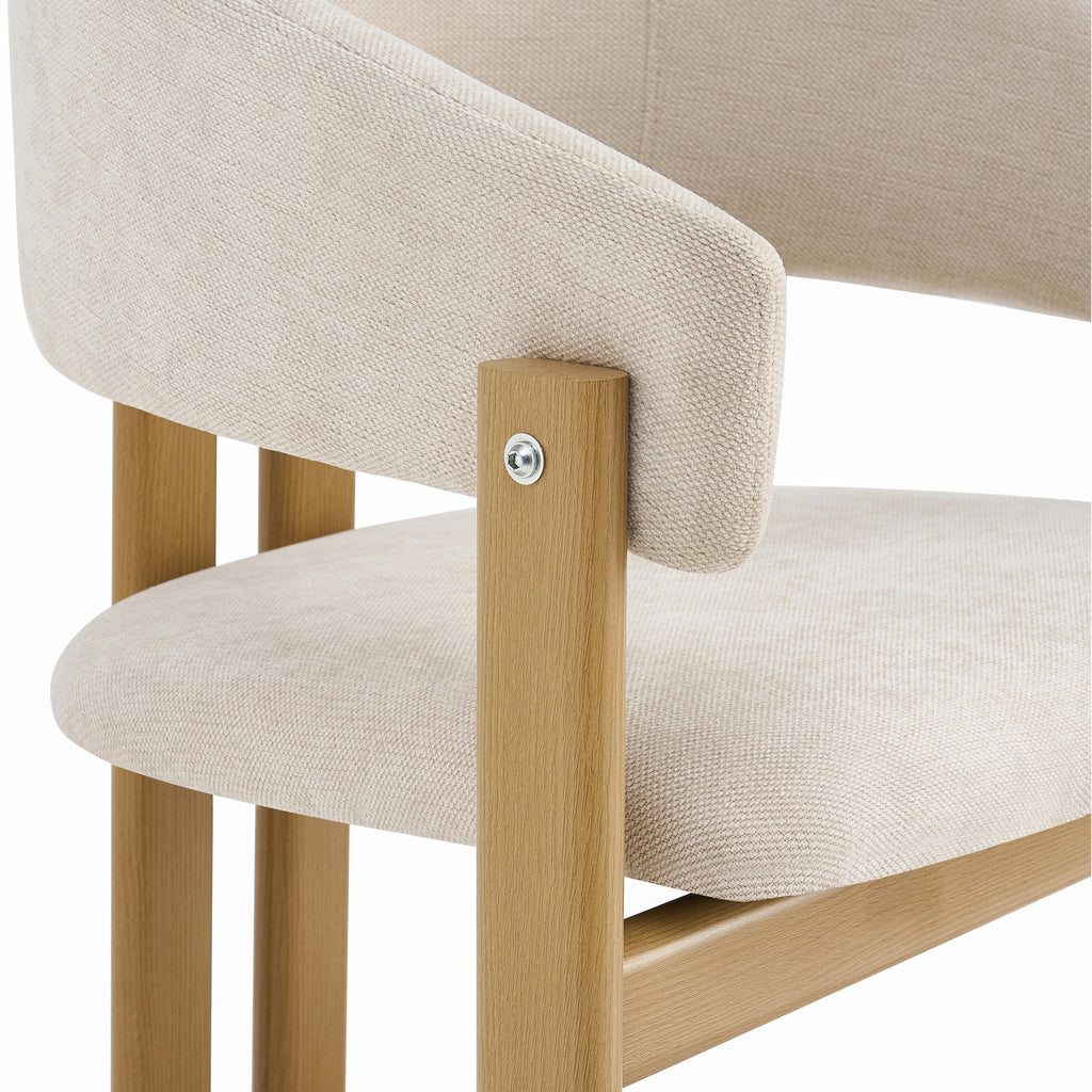 Close-up of a dining chair showing the beige textured fabric upholstery of the seat and curved backrest, attached to a light natural wood frame with a visible silver screw.