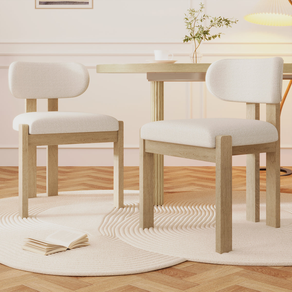 Two wooden chairs with white cushions in a room with a table and decor.